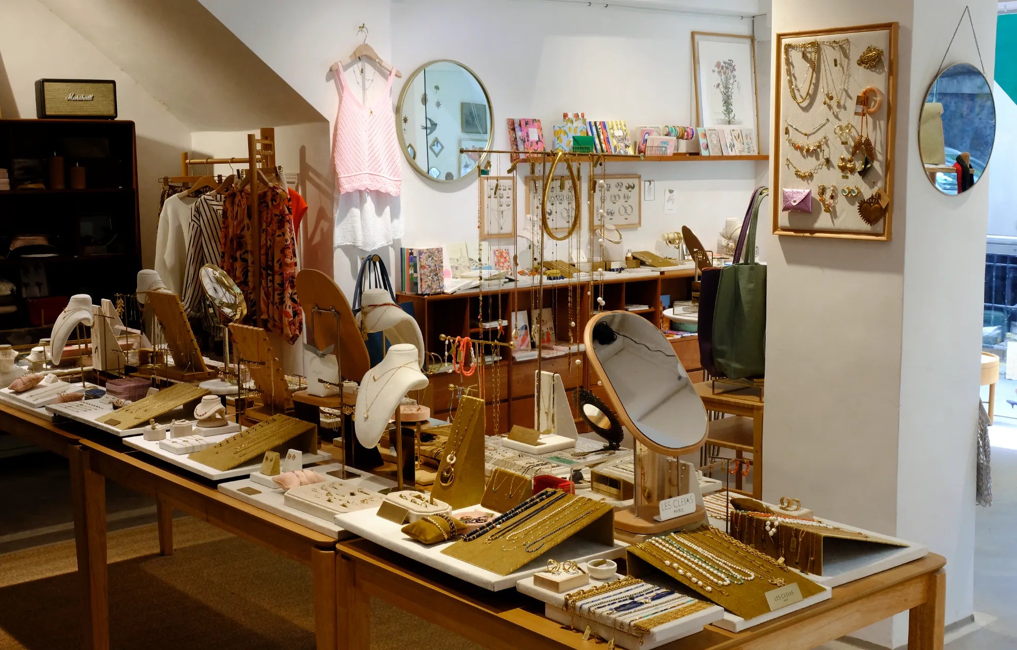 Display of jewelry and accessories in a store with tables and shelves.