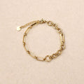 Gold chain bracelet on a beige background