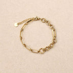 Gold chain bracelet on a beige background