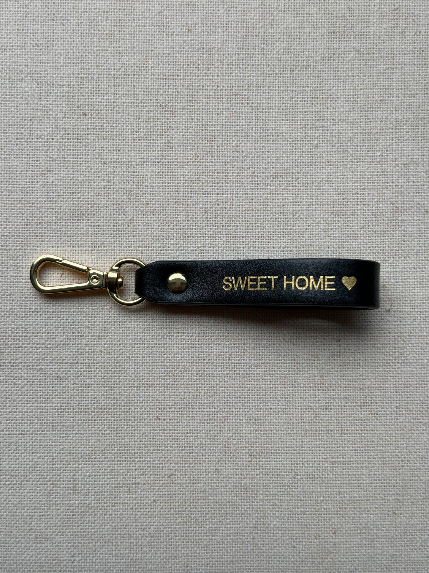 Stylish black leather keychain with leash, with "Sweet Home" printed on it