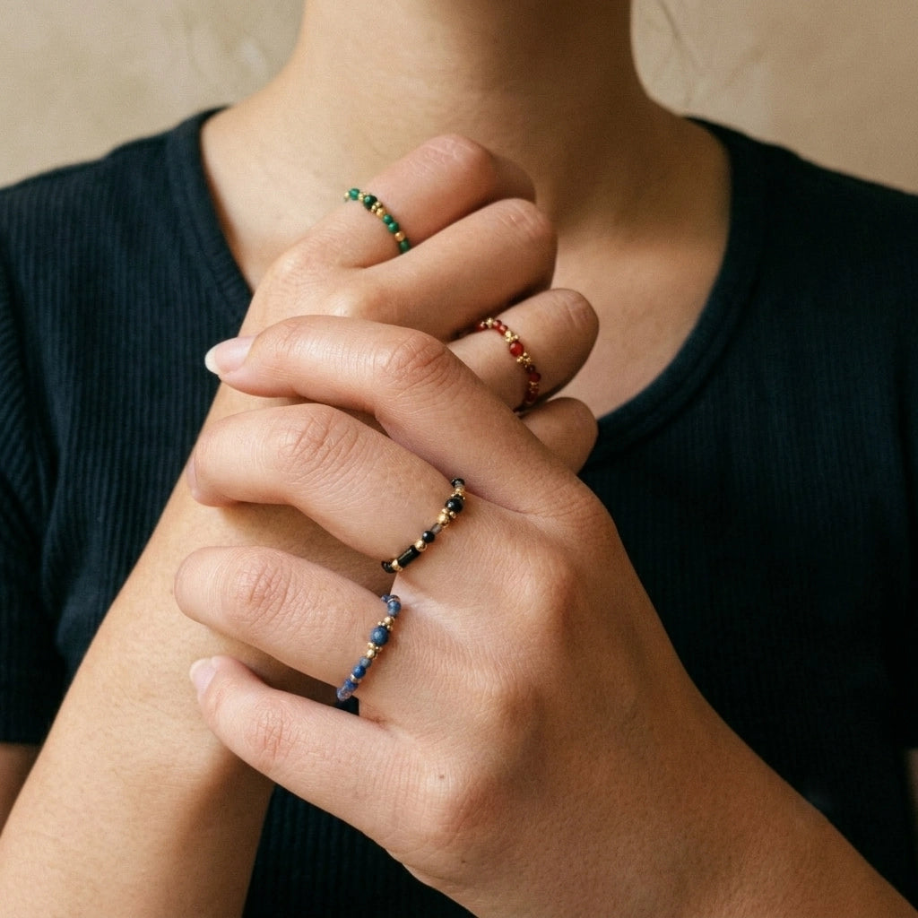 Close-up of hands with beaded bracelets on a neutral background