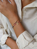 Close-up of a wrist wearing multiple bracelets with a neutral background