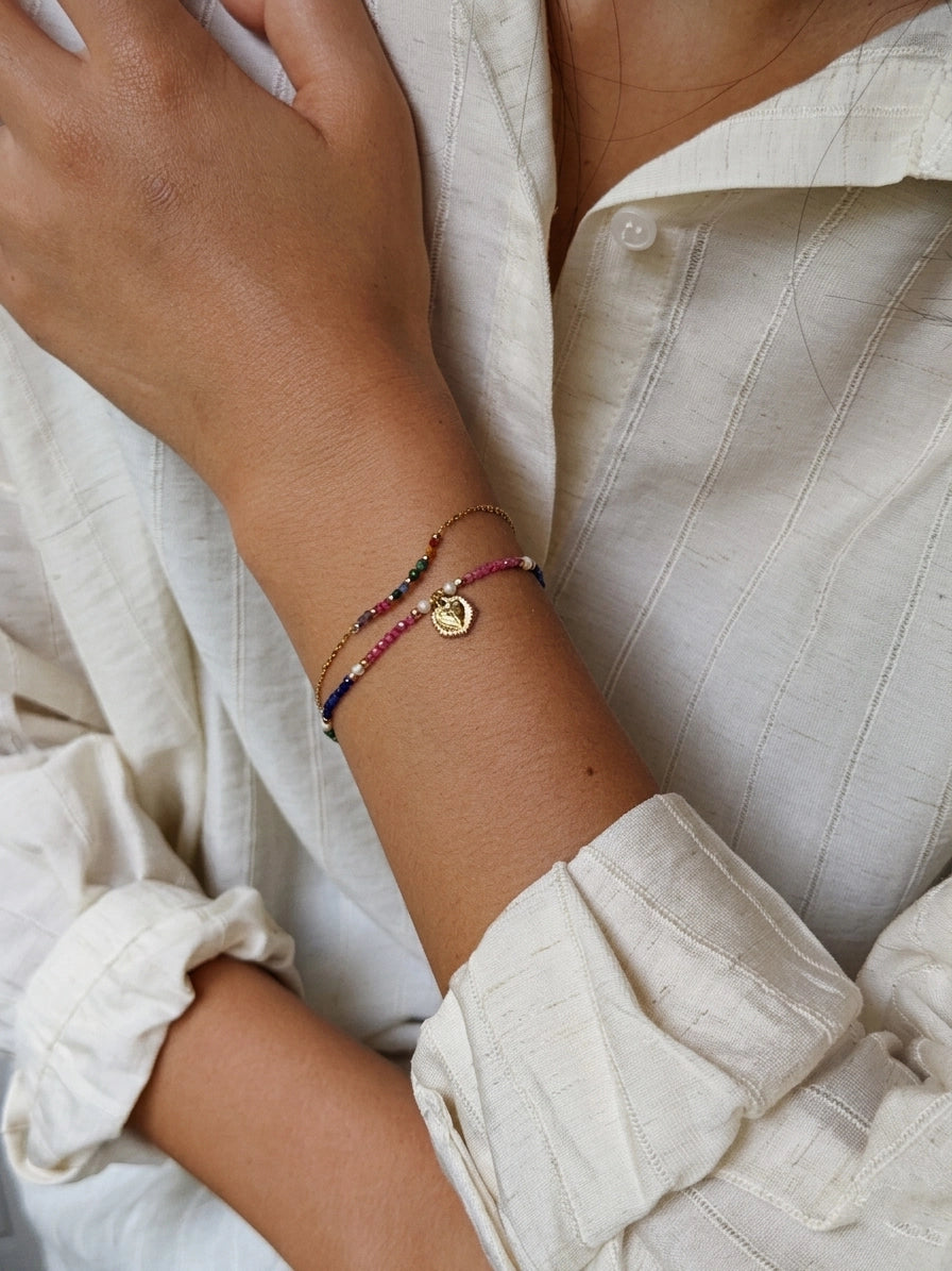 Close-up of a wrist wearing multiple bracelets with a neutral background