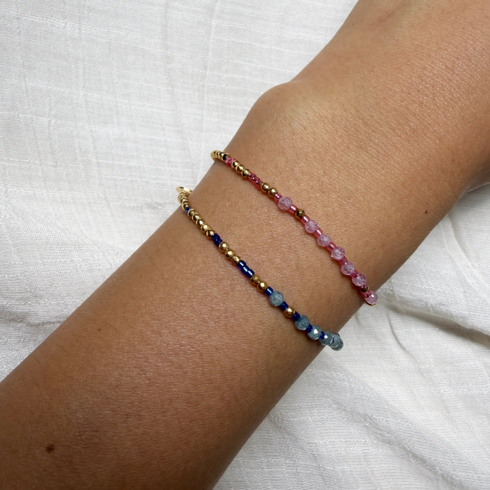 Multicolored beaded bracelet on a wrist against a white background