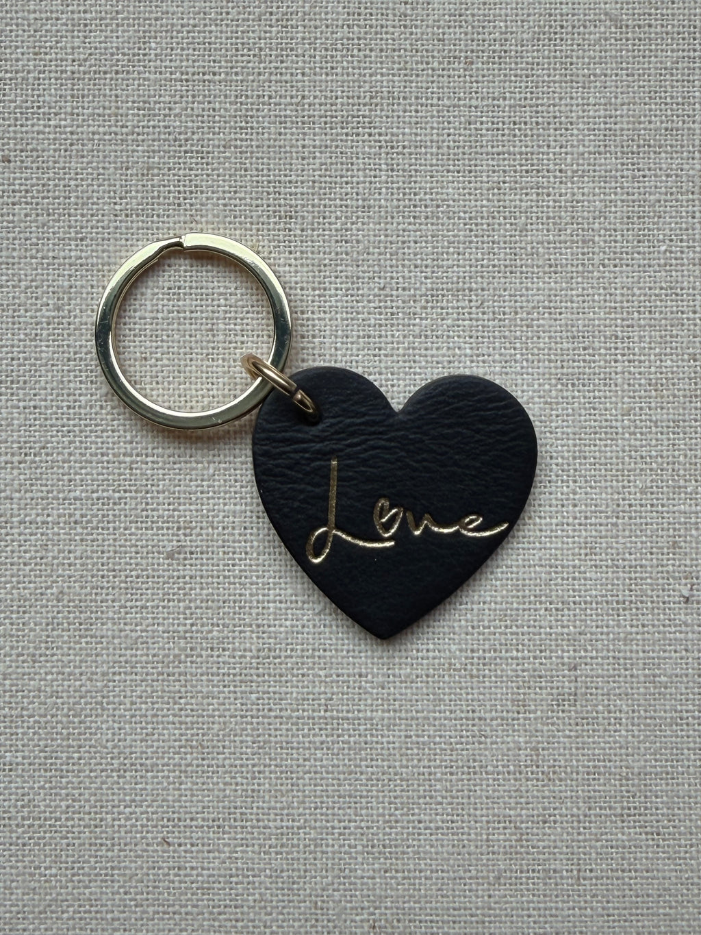 black heart-shaped leather keychain with love on it