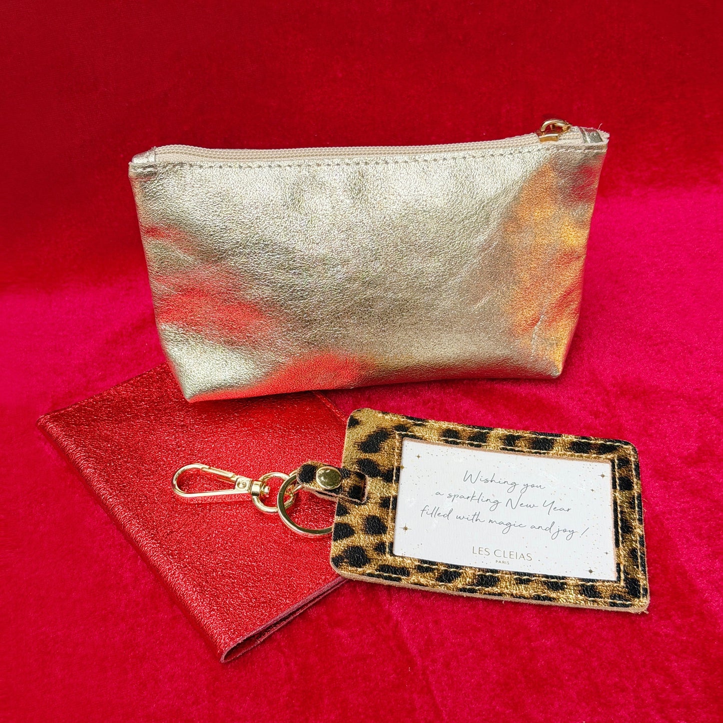 Gold pouch, keychain, and cardholder on a red background