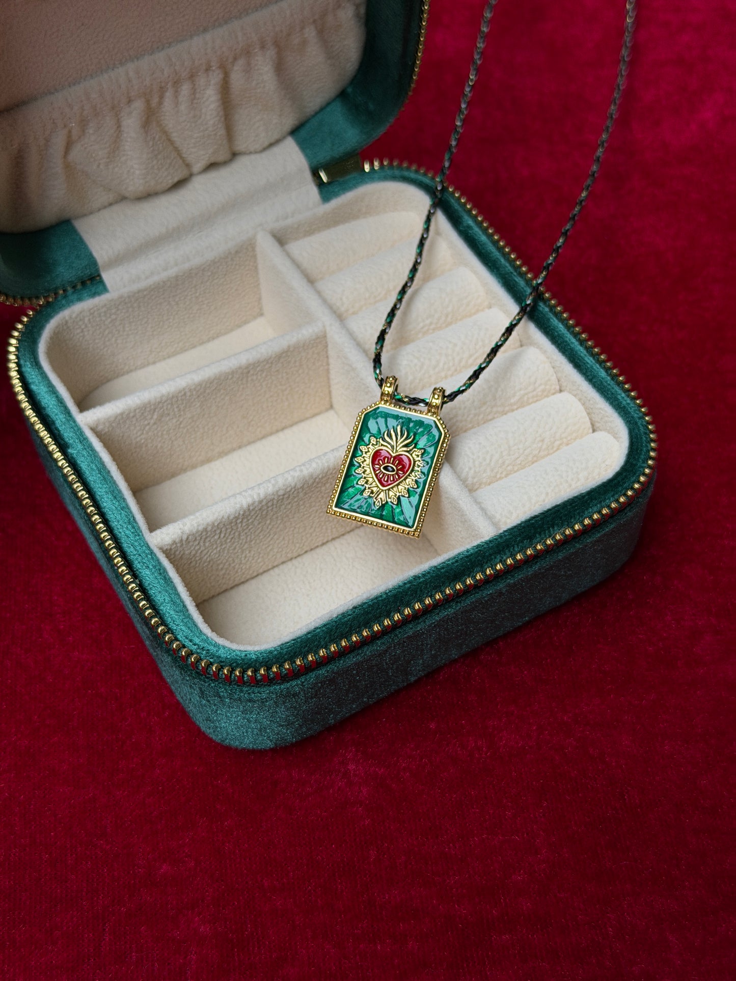 Open jewelry case with a necklace featuring a heart-shaped pendant on a red background