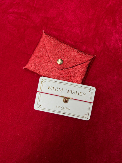 Red leather cardholder with a 'Warm Wishes' card on a red background