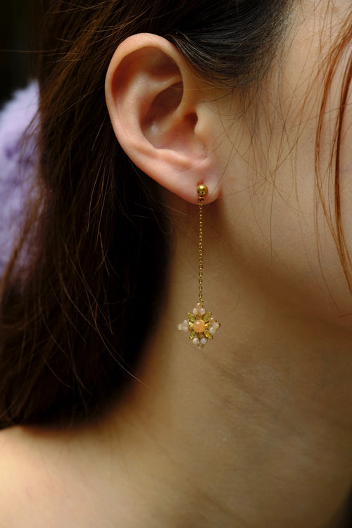 Close-up of a person wearing a gold earring with a star-shaped pendant.