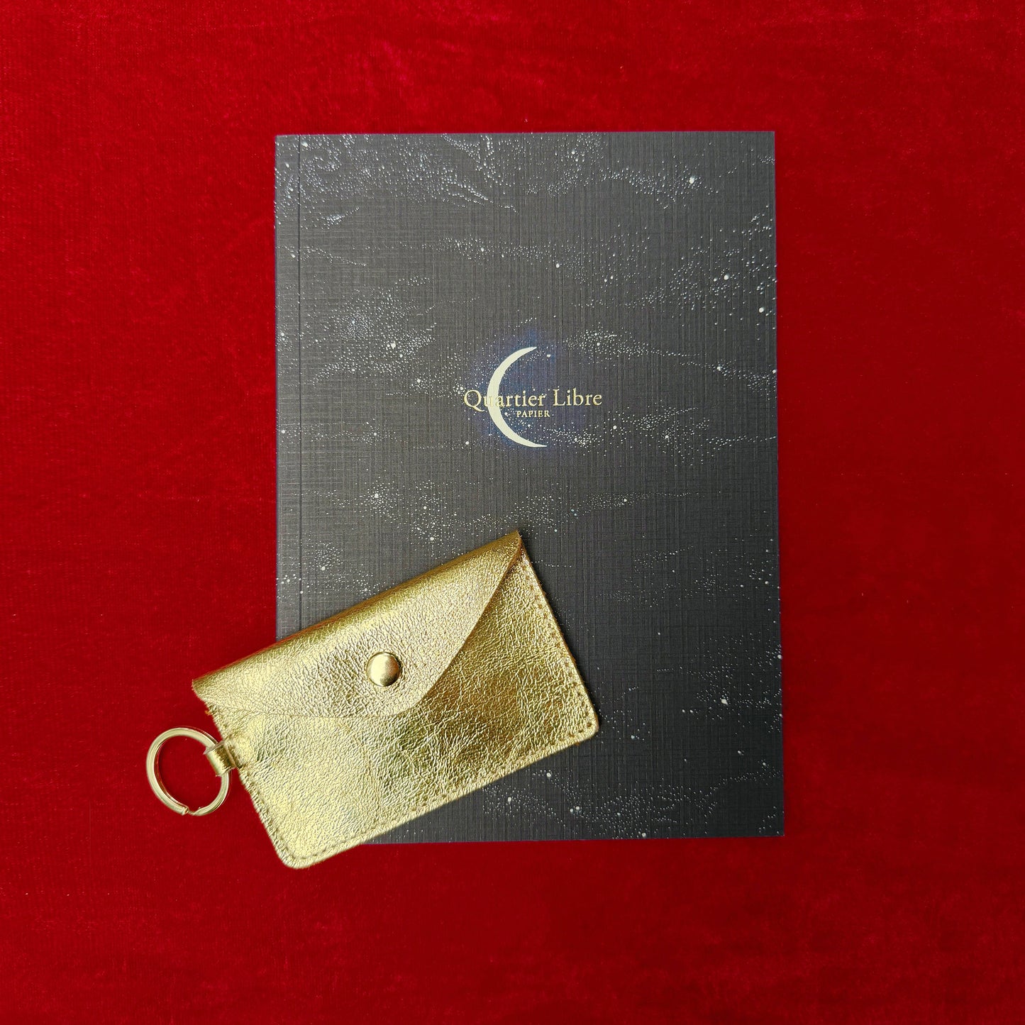 Gold cardholder on a black card with 'Quartier Libre' logo against a red background