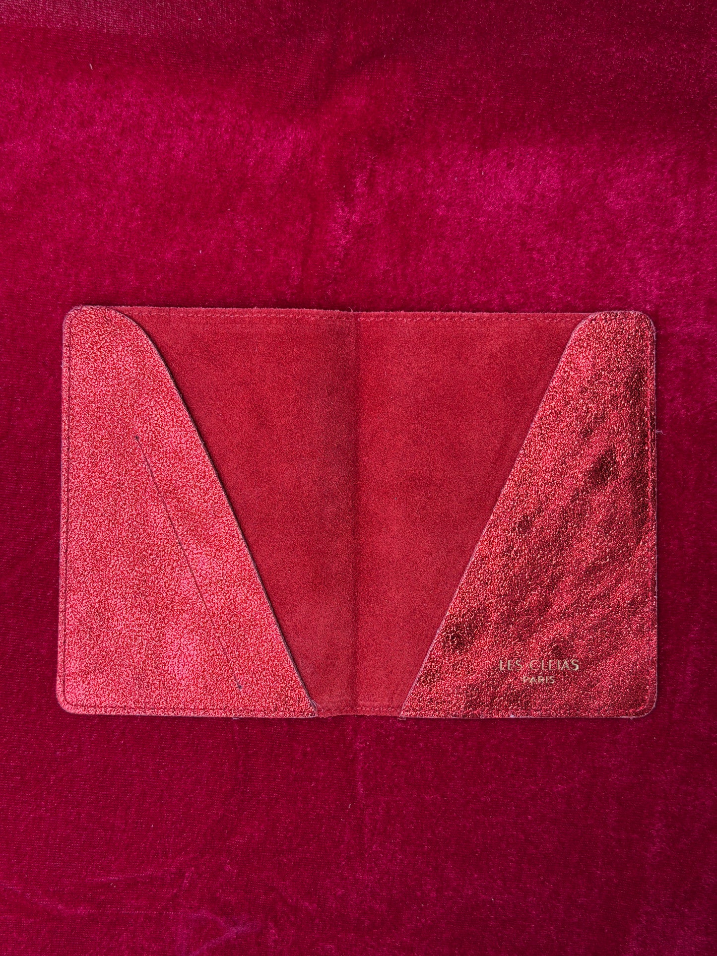 Red leather wallet on a red textured background