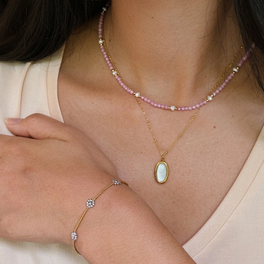Necklace and bracelet set on a person wearing a light-colored top